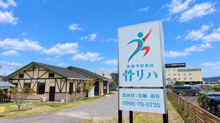 骨リハの施設名と電話番号が記された屋外看板